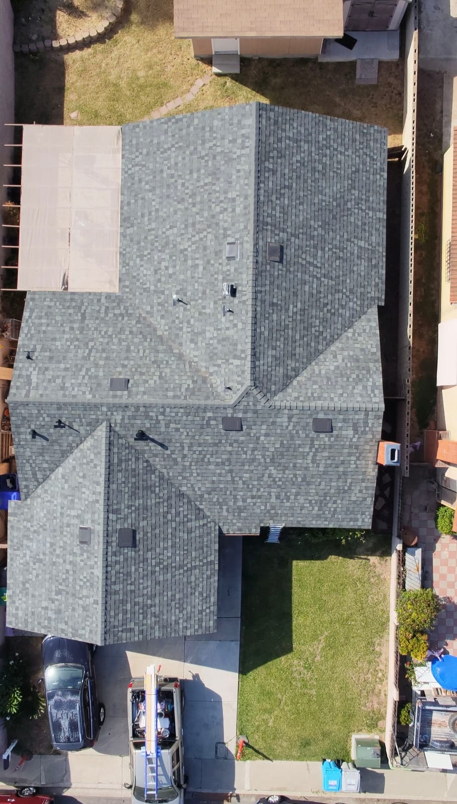 Top-down drone view of a completed shingle roof, every plane and valley finished clean