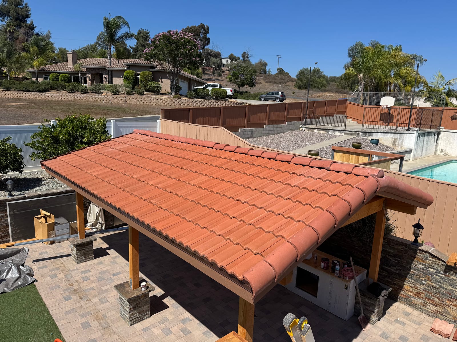 New terracotta tile roof on a backyard patio cover beside the pool